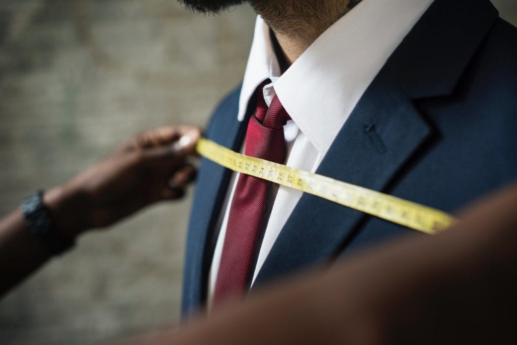 tailor measuring man s chest