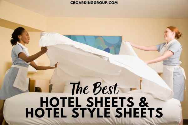 Image of hotel maids unfurling hotel sheets while making bed