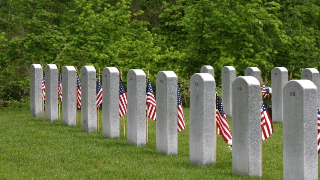 Image of Gravestones at cemetery with flags