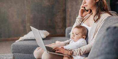 Image of woman working remotely with baby on lap