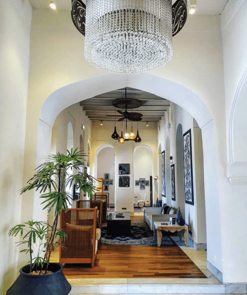 a hallway with a chandelier and a plant