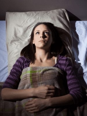 Image of woman lying in bed trying to sleep