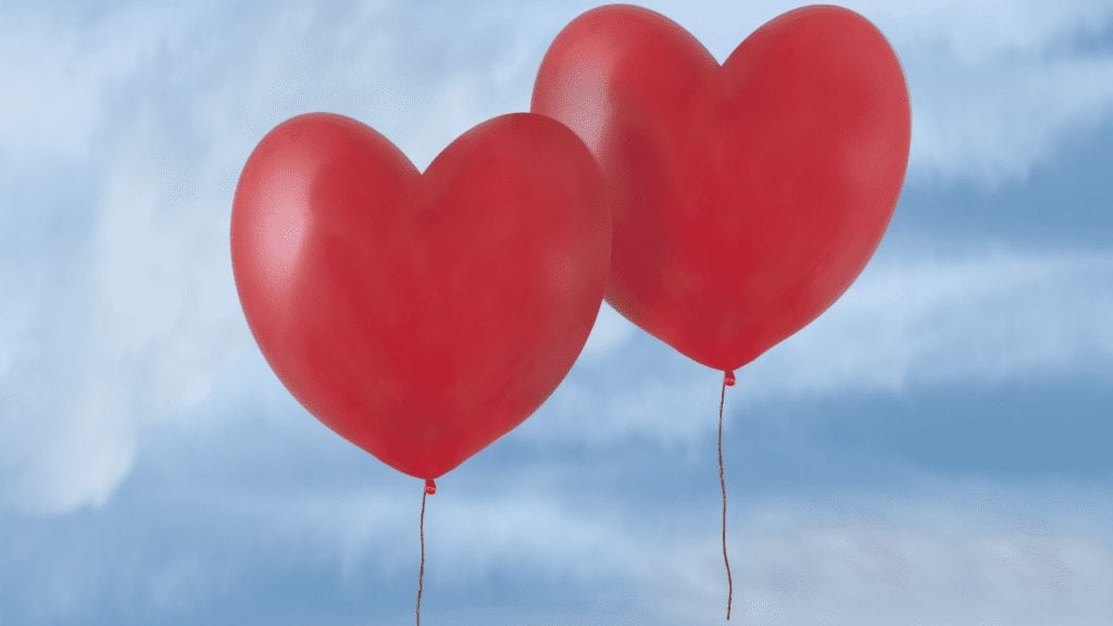 a pair of red heart shaped balloons