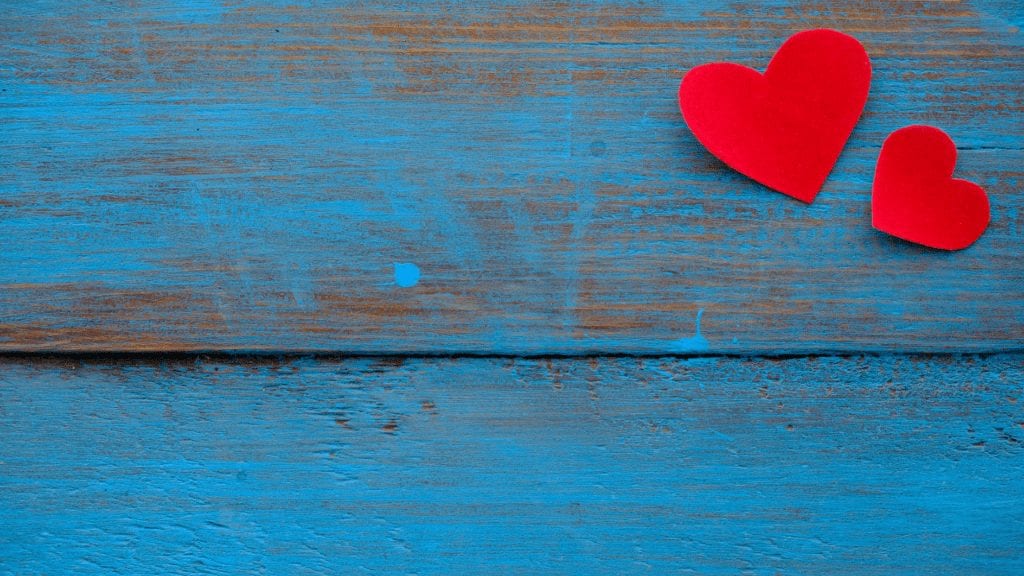 a red heart on a blue wood surface