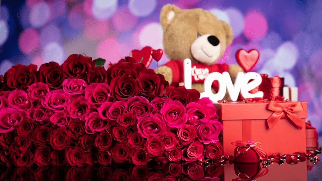 a teddy bear and a box of roses