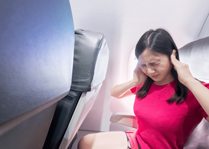 Image of a woman who's ears hurt on an airplane