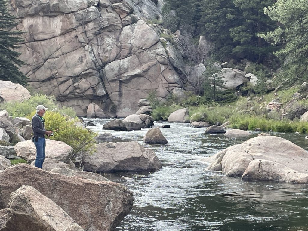 a man standing on rocks near a river