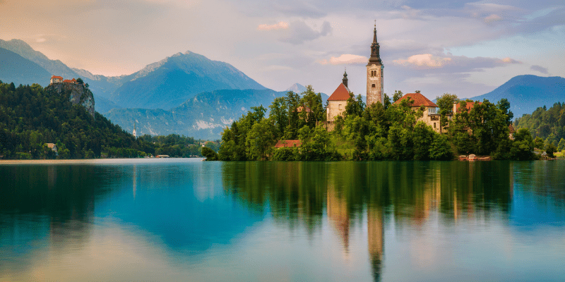 Lake Bled on a small island with trees and mountains in the background